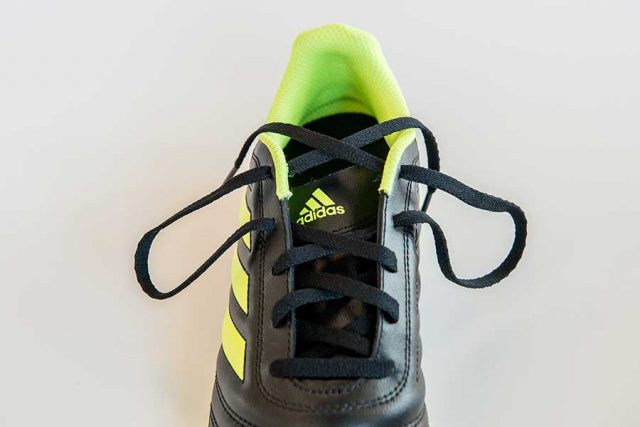 ②上の穴にひもを通して、輪っかを作ります。